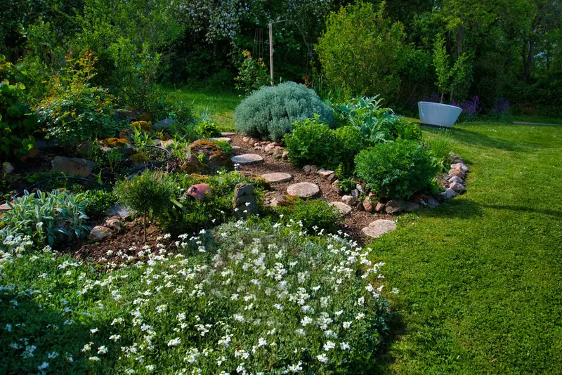 A finished garden with a rock path, flowering beds and lawn.