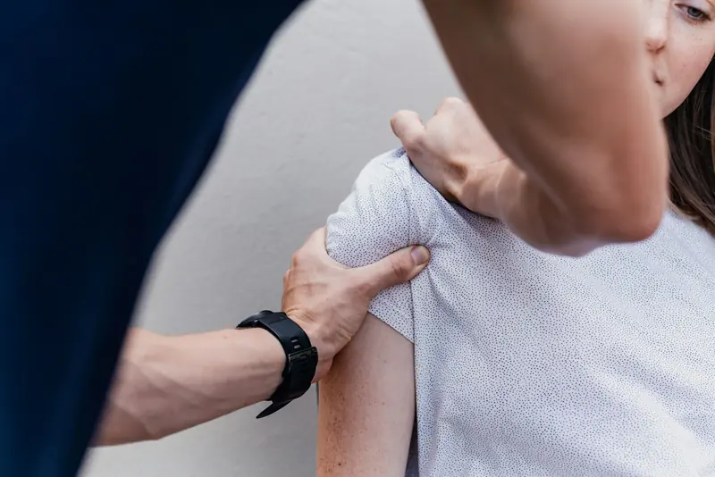 A physio assessing a shoulder.