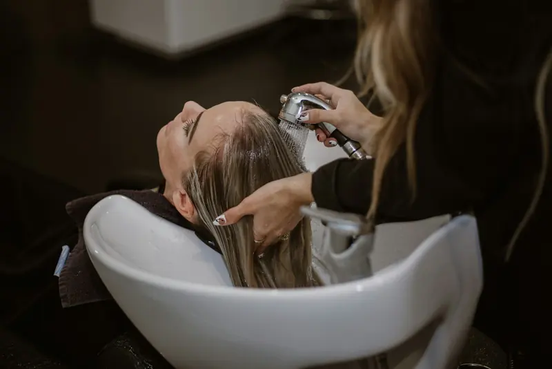 A client having her hair washed at the basin.